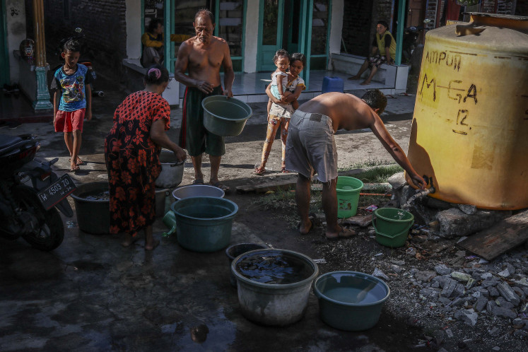 Water for life: Residents of Gempol Sari village line up to fill containers with clean water on May 29, 2021 in Sidoarjo, <a class=