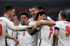 England's defender Bukayo Saka is mobbed by teammates after scoring the opening goal during the international friendly football match between England and Austria at the Riverside Stadium in Middlesbrough, north-east England on June 2, 2021.