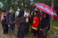 A group of Rohingya refugees gather on a beach after arriving at Pulau Idaman, a small island off the coast of East Aceh in northern Sumatra on June 4, 2021. 