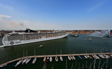 Tugboats escort the MSC Orchestra cruise ship across the basin as it leaves Venice on June 05, 2021. 