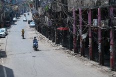 Motorists make their way through a partially deserted closed market during a lockdown imposed as a preventive measure to curb the spread of the Covid-19 coronavirus in New Delhi on June 5, 2021. 