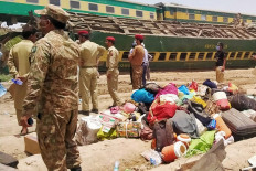 Security personnel stand at the site of a train accident in Daharki area of the northern Sindh province on June 7, 2021, as at least 34 people were killed and dozens injured when a packed Pakistani inter-city train ploughed into another express that had derailed earlier, officials said. 