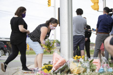 People pay their respects at the scene where a man driving a pickup truck struck and killed four members of a Muslim family in London, Ontario, Canada on June 7, 2021. 