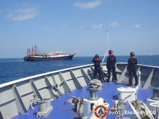 Philippine Coast Guard personnel survey several ships believed to be Chinese militia vessels in Sabina Shoal in the South China Sea, in a handout photo distributed by the Philippine Coast Guard on May 5 and taken according to source on April 27, 2021.
