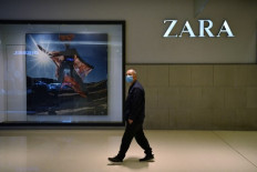 A man walks past a Zara clothing store in Beijing.