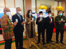 Flexibility: Bank Mandiri Vice President Alexandra Askandar (third left) and Director General of General Legal Administration Cahyo Rahadian Muhzar (second left) pose together while holding cards during the launch of the bank&rsquo;s fiduciary warranty service in Bali on Thursday.