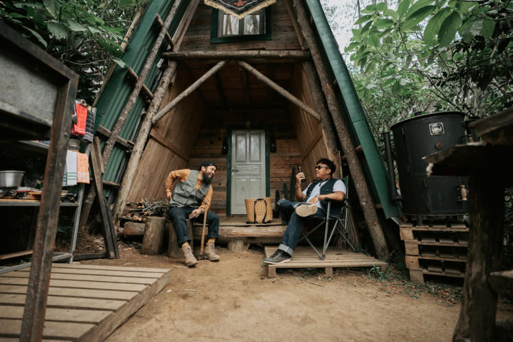 Back to nature: Gianjar and Hedi relax in front of Saux Farm's wooden cabin.