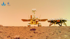 This undated handout photograph released on June 11, 2021 by the China National Space Administration (CNSA) shows an image taken by a camera released from China's Zhurong Mars rover showing the rover (left) and the landing platform on the surface of Mars. 