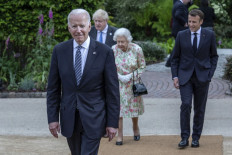 US President Joe Biden (left), Britain's Prime Minister Boris Johnson (2nd left), Britain's Queen Elizabeth II (center) and France's President Emmanuel Macron (right) arrive for a family phtotograph during a reception at The Eden Project in south west England on June 11, 2021. G7 leaders from Canada, France, Germany, Italy, Japan, the UK and the United States meet this weekend for the first time in nearly two years, for three-day talks in Carbis Bay, Cornwall.