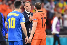 Netherlands' defender Daley Blind (right) is greeted by Netherlands' coach Frank de Boer (center) after being substituted during the UEFA EURO 2020 Group C football match between the Netherlands and Ukraine at the Johan Cruyff Arena in Amsterdam on June 13, 2021. 