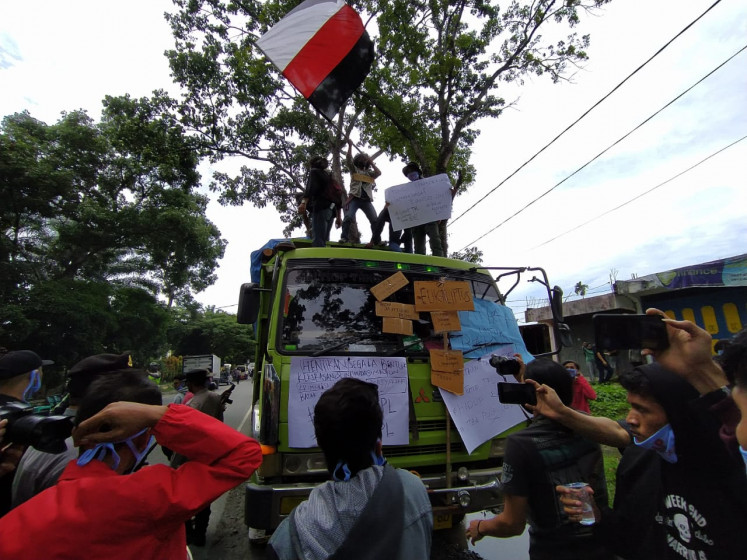 Stay off our land: A group of university students block a truck belonging to PT Toba Pulp Lestari in North Sumatra.
