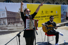 Musician Ozge Metin (L) sings to a dancing crowd in Istanbul on June 9, 2021 as the Istanbul Municipality has launched the "Istanbul is a Stage" project, allowing musicians to sing and dance on open squares. Bars and restaurants have reopened as Turkey pulls out of the Covid-19 pandemic's third wave, but the musicians feel unfairly singled out.