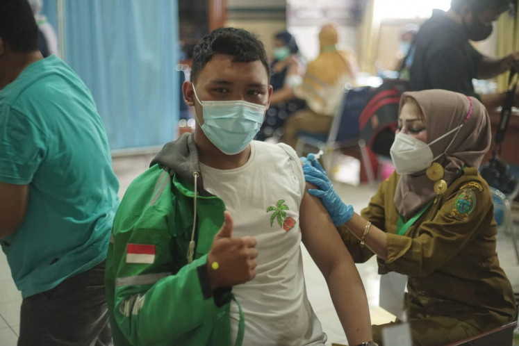 A Grab motorcycle driver receives COVID-19 vaccine on 27 April 2021 at Grab's vaccination center in Medan, North Sumatra.