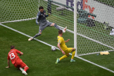 Ukraine's forward Andriy Yarmolenko (R) scores the opening goal past North Macedonia's goalkeeper Stole Dimitrievski (C) during the UEFA EURO 2020 Group C football match between Ukraine and North Macedonia at the National Arena in Bucharest on June 17, 2021.