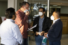 Plastic surgeon Ridwan Mia (2nd R), who will perform surgery Rodwell Khomazana, 9, can be seen outside of the Mediclinic Sandton Hospital before the arrival of Khomazana in Sandton on June 19, 2021. Plastic surgeons in South Africa are preparing to reconstruct the face of a Zimbabwean boy mauled by a hyena during a night time church service last month.
