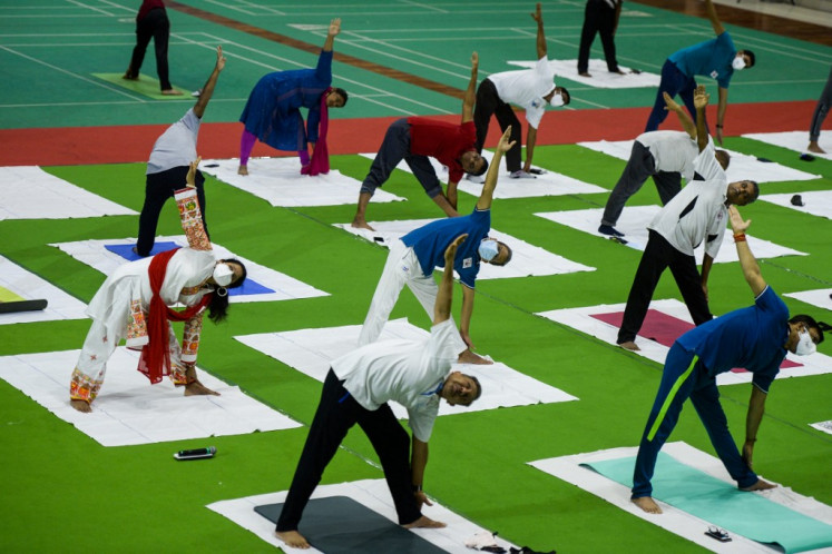Railway officials participate in a yoga session to mark International Yoga Day in Hyderabad on June 21, 2021.
