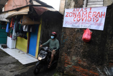 A motorist passes an alley in South Gandaria subdistrict, Cilandak district, South Jakarta on June 21, 2021. A neighborhood in the subdistrict is put under local lockdown due to the high number of COVID-19 cases confirmed in the area. 