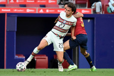 Portugal's forward Joao Felix (L) vies with Spain's midfielder Sergio Busquets during the international friendly football match between Spain and Portugal at the Wanda Metropolitano stadium in Madrid in preperation for the UEFA European Championships, on June 4, 2021.