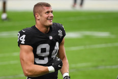 In this file photo Carl Nassib #94 of the Las Vegas Raiders flexes while smiling during warmups before a game against the Denver Broncos at Allegiant Stadium on November 15, 2020 in Las Vegas, Nevada. 