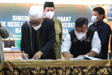 Indonesian Ulema Council (MUI) president Miftachul Akhyar (left) signs a memorandum of understanding at the MUI headquarters in Jakarta with Ahyudin (right), president of now defunct nonprofit Aksi Cepat Tanggap (ACT), in this file photo from June 2021.