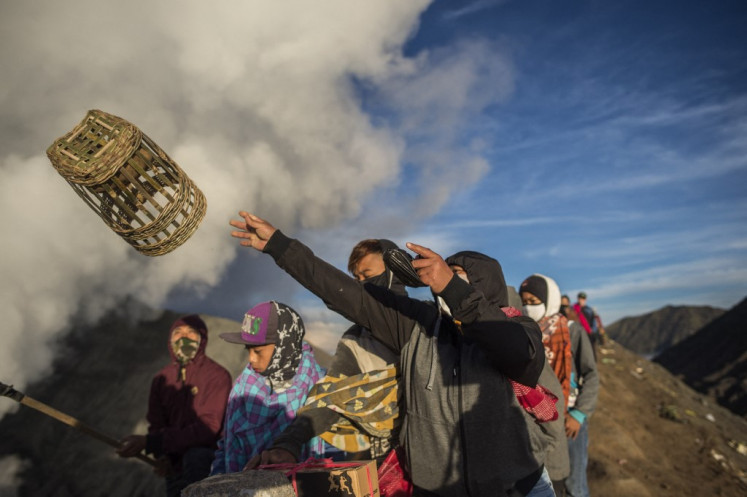 Tengger tribe people throw their offerings into the crater of the active Mount Bromo volcano to make offerings in Probolinggo, East Java province on June 26, 2021, during the Yadnya Kasada festival to seek blessings from the main deity by presenting offerings of rice, fruit, livestock and other items. 