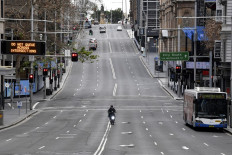 A food delivery worker rides in the central business district of Sydney on June 26, 2021, as Australia's largest city entered a two-week lockdown to contain an outbreak of the highly contagious Delta variant. 