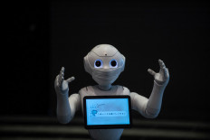 This file photo taken on May 1, 2020 shows a greeting robot called Pepper gesturing to the media in a hotel lobby during the first day the building is used as a new medical lodging facility to accommodate COVID-19 coronavirus patients with mild symptoms in Tokyo. 