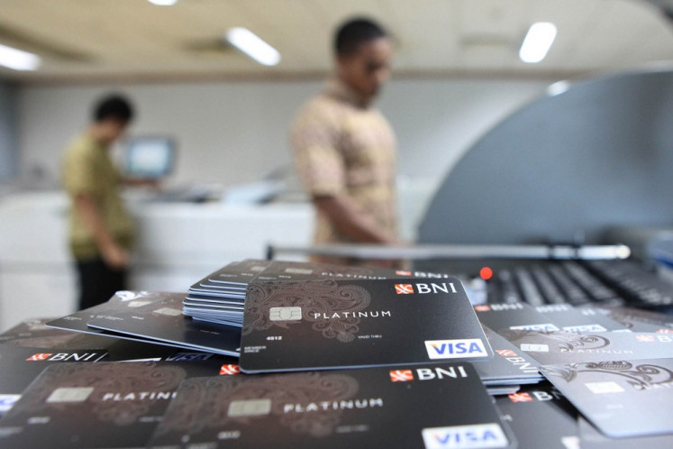 Cashless economy: State-owned bank BNI employees print credit cards on Aug. 10, 2012, at the lender&rsquo;s Card Business Division in Jakarta. Bank Indonesia (BI) has cut the interest rate for credit cards from a maximum of 2 percent to 1.75 percent per month, effective on Thursday. 