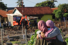 Family members grieve at a cemetary in Tangerang, in the suburbs of Jakarta on July 2, 2021, as Covid-19 infections surged to record levels topping 21,000 per day in Southeast Asia's worst-hit nation. 