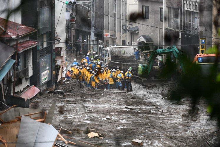 Police search for missing people at the scene of a landslide following days of heavy rain in Atami in Shizuoka Prefecture on July 4, 2021.