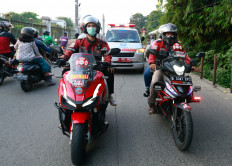 Volunteer bikers escort an ambulance to a cemetery as coronavirus disease (COVID-19) cases surge in Depok on the outskirts of Jakarta, Indonesia, July 2, 2021.