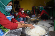Family Welfare Movement (PKK) members in community unit (RW) 05 in Jagakarsa, South Jakarta prepare food packages on June 30. The community-run public kitchen provides food for local residents undergoing self-isolation or affected by the COVID-19 pandemic.