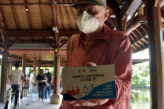A foreigner shows his vaccination card after receiving the second dose of a COVID-19 vaccine in Sanur, Denpasar, Bali on June 22, 2021.