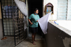 A woman puts away a white flag after she received help from others at her home during an enhanced lockdown, amid the coronavirus disease (COVID-19) outbreak, in Petaling Jaya, Malaysia July 6, 2021. 