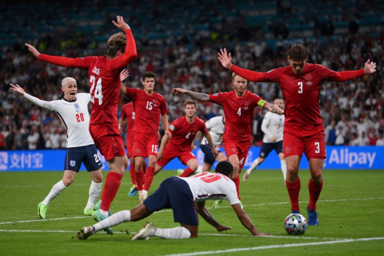 England's forward Raheem Sterling (C) falls on the ground which led to the awarding of a penalty during the UEFA EURO 2020 semi-final football match between England and Denmark at Wembley Stadium in London on July 7, 2021.
