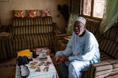 Malian photographer Django Cissé, 76, known as the initiator of the postcard in Mali, looks through some of his postcards in his home in Bamako on June 26, 2021.