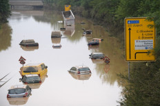 Submerged cars and other vehicles are seen on the federal highway B265 in Erftstadt, western Germany, on July 17, 2021, after heavy rains hit parts of the country, causing widespread flooding and major damage. Rescue workers scrambled on July 17 to find survivors and victims of the devastation wreaked by the worst floods to hit western Europe in living memory, which have already left more than 150 people dead and dozens more missing.