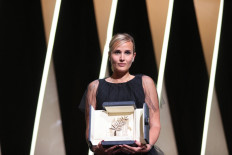 French director Julia Ducournau poses on stage with her trophy after she won the Palme d'Or for her film 