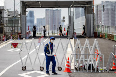 A security personnel stands guard at the entrance of the Tokyo 2020 Olympic and Paralympic Village in Tokyo on July 14, 2021, ahead of the 2020 Tokyo Olympics which begin on July 23. 