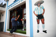 A fan kneels at the entrance to the first Mexico's church in memory of soccer legend Diego Armando Maradona in San Andres Cholula, in Puebla state, Mexico July 14, 2021. 