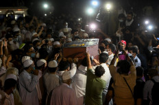 Mourners carry the casket of Reuters journalist Danish Siddiqui (R) before his burial in New Delhi on July 18, 2021, after the Pulitzer Prize-winning photographer with Reuters news agency was killed covering fighting between Afghan security forces and the Taliban near a border crossing with Pakistan.