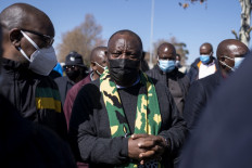 South African President Cyril Ramaphosa (C) visits the Maponya mall to speak to members of the public and discuss the damages caused by recent looting and destruction in Soweto on July 18, 2021. The violent rioting and looting risks deterring foreign visitors and hammering hopes of recovery, the industry says, compounding losses caused by COVID-19.