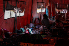Waiting: Patients lie in an emergency tent in front of Chasbullah Abdulmadjid Regional Hospital in Bekasi, West Java, on July 25. The emergency tent functioned as triage room for admittance to the hospital. 