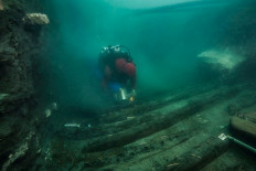 A diver examines the remains of an ancient military vessel discovered in the Mediterranean sunken city of Thonis-Heracleion off the coast of Alexandria, Egypt, in this handout image released on July 19, 2021. 