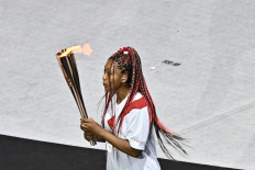 Japan's tennis player Naomi Osaka carries the Olympic torch in the Olympic Stadium during the opening ceremony of the Tokyo 2020 Olympic Games, in Tokyo, on July 23, 2021. 