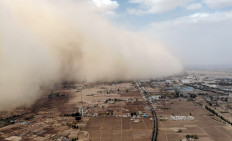 This aerial photo taken on April 25, 2021 shows a sandstorm engulfing a village in Linze county, in the city of Zhangye in China's northwestern Gansu province. 