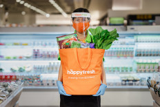A HappyFresh shopper carries a bag full of groceries. The company announced on July 27, 2021 that it had received US$65 million in its latest funding round.
