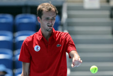 Russia's Daniil Medvedev takes a ball as he competes against Italy's Fabio Fognini during their Tokyo 2020 Olympic Games men's singles third round tennis match at the Ariake Tennis Park in Tokyo on July 28, 2021.
