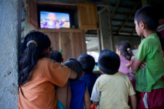 Children watching a television show in the community hall on May 22, 2014.