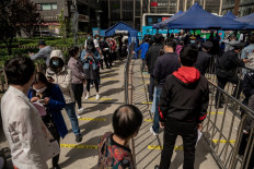 People line up to get vaccinated against the Covid-19 coronavirus, on a mobile vaccination bus outside a residential area in Beijing on April 27, 2021. 